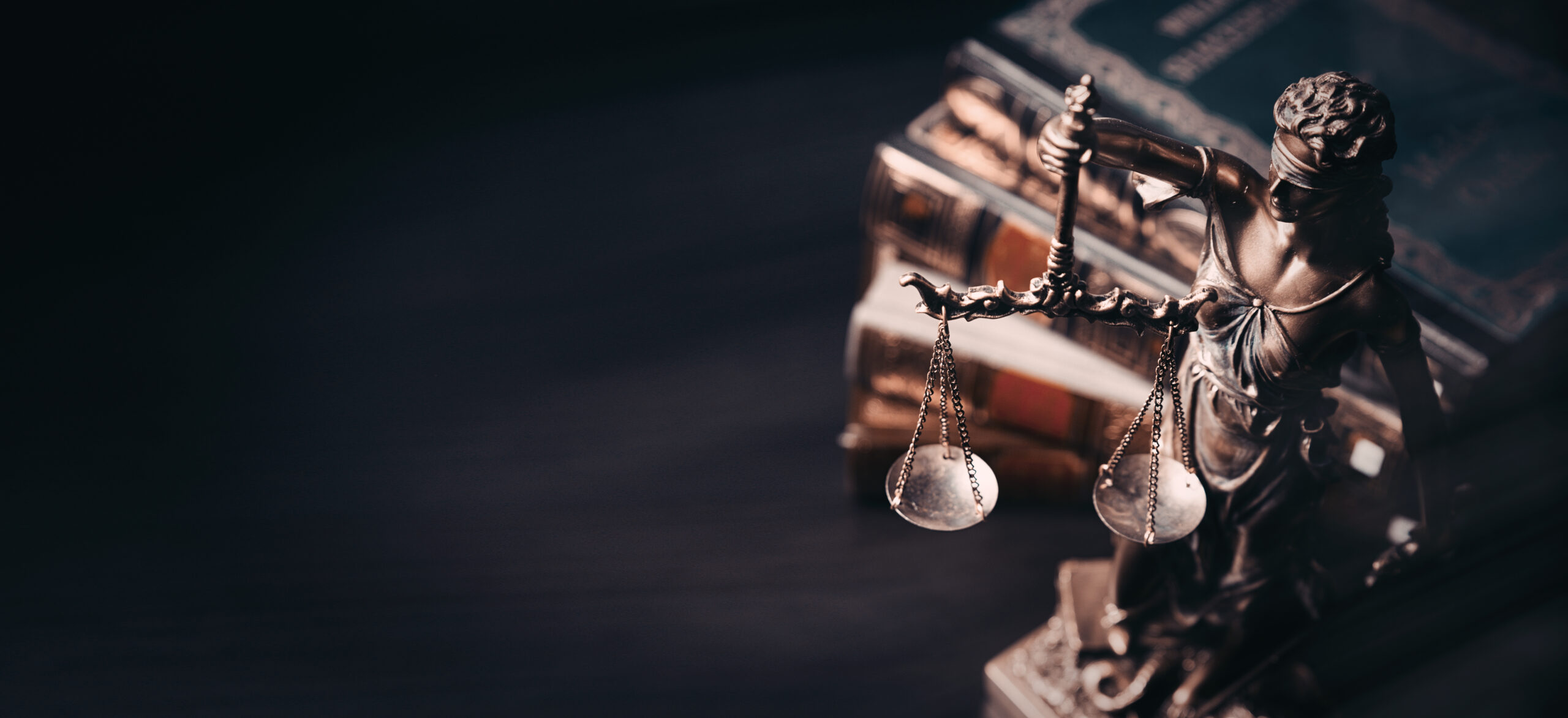 Bronze Lady Justice statue with scales and law books symbolizing fairness and legal integrity – Forefront Investigations